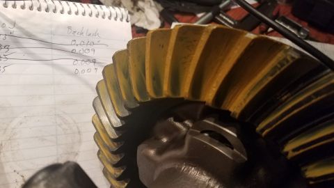 1985 Ford Bronco - A close-up shot shows a yellow and black differential gear next to a notebook with handwritten notes about backlash measurements.