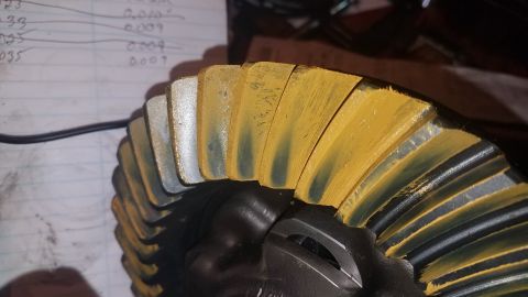 1985 Ford Bronco - A close-up view of a differential ring gear, likely from a 1985 Ford Bronco, showing wear pattern marks from contact with a pinion gear. Th…