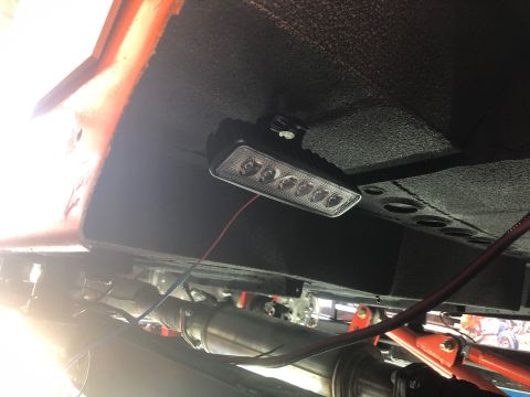 1992 Jeep Wrangler - An aftermarket LED light bar is mounted underneath the chassis of a vehicle, with red and blue wires connected to it. The underside of the…
