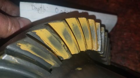 1985 Ford Bronco - A close-up view of a gear with yellow marking compound applied to its teeth. A handwritten note in the background reads "Depth: 0.009".