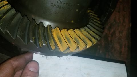 1985 Ford Bronco - A close-up view of a differential gear with yellow marking compound on its teeth. Text on the gear reads "18 C 19 170F53085 913A592". A pie…