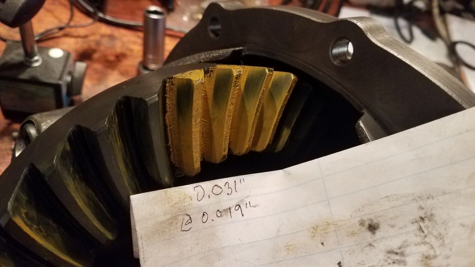 Close-up of differential ring gear with yellow marking compound on teeth.