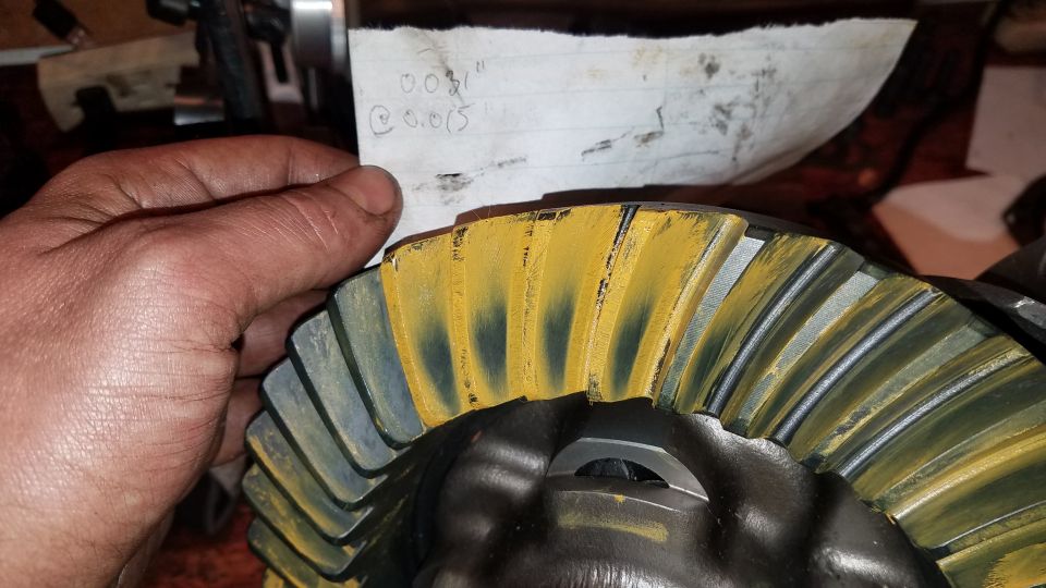 Differential gear with yellow marking compound and a note with measurements.