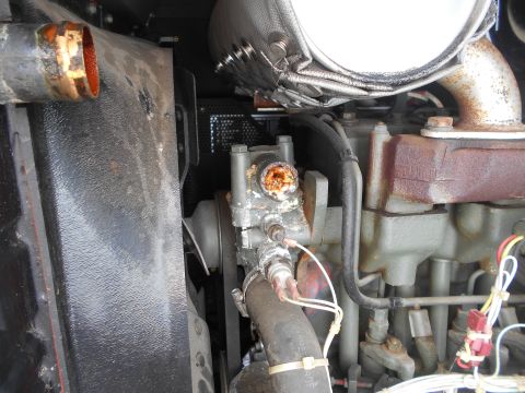 1992 Ford Bronco - Close-up view of a heavily corroded engine component, possibly a water pump or thermostat housing, with visible rust and mineral deposits.…