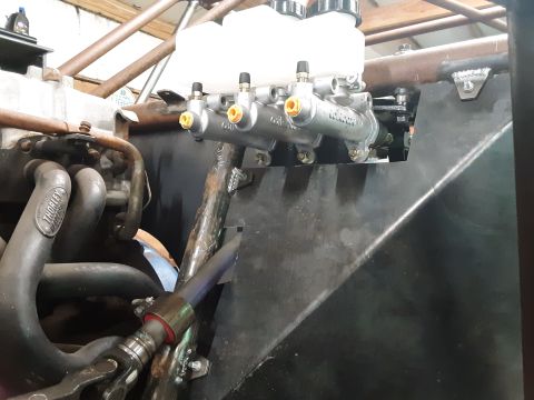 1985 Toyota Hilux - A close-up view of a dual brake master cylinder assembly mounted to a custom bracket in what appears to be a vehicle engine bay. The assemb…
