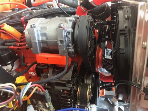1992 Jeep Wrangler - A close-up view of the engine bay of a Jeep Wrangler shows the air conditioning compressor, alternator, and cooling fan assembly. The engin…