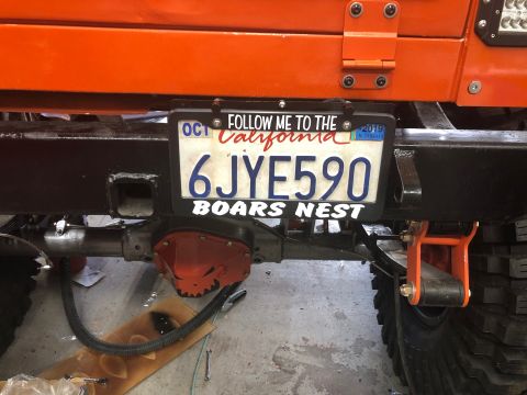 1992 Jeep Wrangler - The rear of an orange Jeep Wrangler is shown, featuring a California license plate that reads "6JYE590" and "BOARS NEST". The vehicle has a…