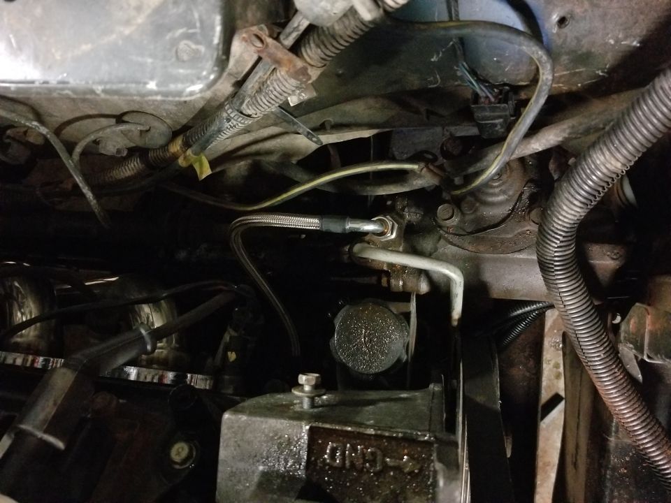 Braided metal hose connected to engine component in a 1991 Mitsubishi Montero engine bay.