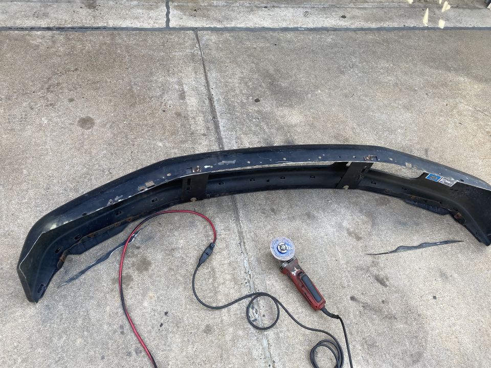 Black bumper on concrete with power cord and angle grinder