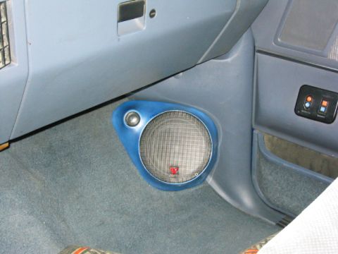 1989 Ford Bronco - Custom-built blue fiberglass kick panel pod in a truck footwell housing a mesh-grilled woofer with a smaller tweeter mounted above it. The…