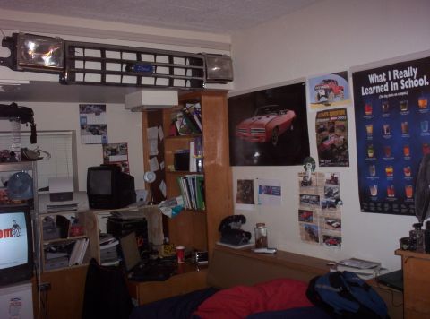 1988 Ford Bronco - A Ford grille and headlight are mounted on the wall above a desk in a room.