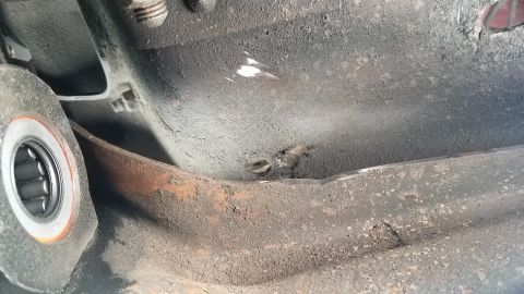 1985 Ford Bronco - A close-up view shows a heavily soiled metal component with a visible bearing assembly on the left. The surface appears aged and shows sign…