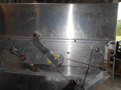 1992 Ford Bronco - Close-up view of a mechanical assembly with cables, levers, and metal components. Text is visible on the metal panels, including "40274 AMS…