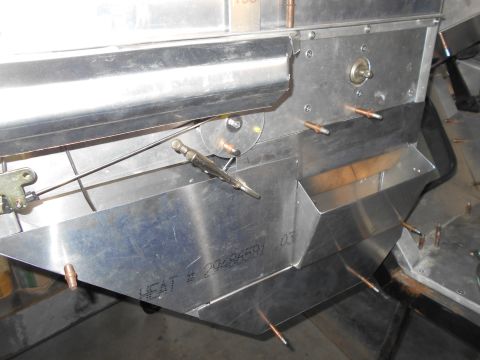 1992 Ford Bronco - A close-up view of the aluminum construction of a vehicle's interior, showing a cable mechanism attached to a metal plate. Text visible on…