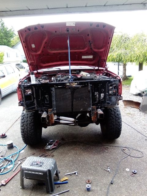 1994 Ford Bronco - A red SUV is parked outdoors with its hood open, revealing the engine bay.