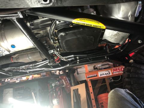 1992 Jeep Wrangler - Underside view of a vehicle's drivetrain, showing a transmission, driveshaft with a "4XSHAFT.COM CUSTOM DRIVE SHAFTS" sticker, and exhaust…
