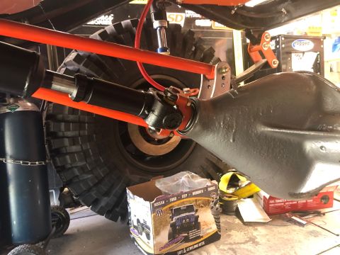 1992 Jeep Wrangler - A close-up view of the rear axle and driveshaft of an off-road vehicle, with a large tire and suspension components visible. A box for lift…