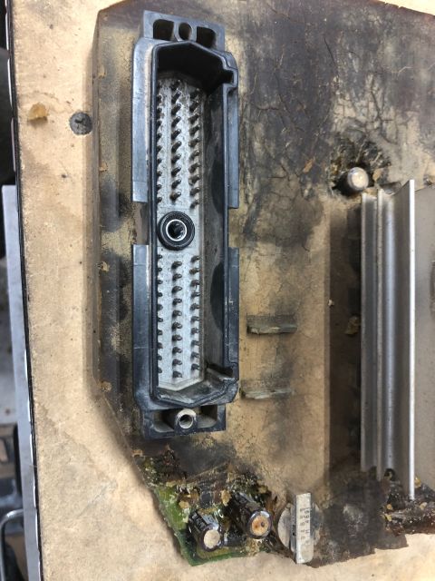 1992 Jeep Wrangler - A close-up view of a damaged electronic control unit (ECU) connector and circuit board, likely from a 1992 Jeep Wrangler. The connector pin…