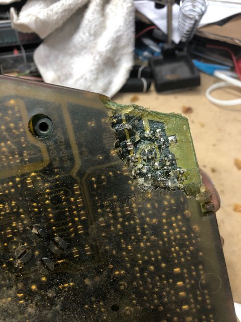 1992 Jeep Wrangler - A close-up view of a damaged electronic circuit board with visible corrosion and burnt components.