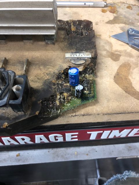 1992 Jeep Wrangler - A close-up view of a damaged electronic circuit board with melted components and a heatsink. The board appears to be part of an automotive…