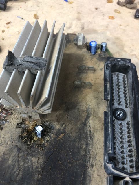 1992 Jeep Wrangler - A close-up view of electronic components on a circuit board, including a large heatsink, capacitors, and a multi-pin connector. The board a…