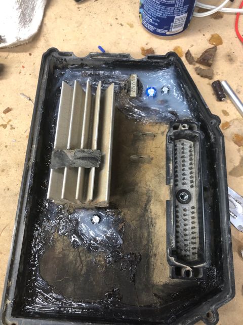 1992 Jeep Wrangler - The inside of a black plastic enclosure is shown, filled with various electronic components and sealant. A large heatsink is visible on the…