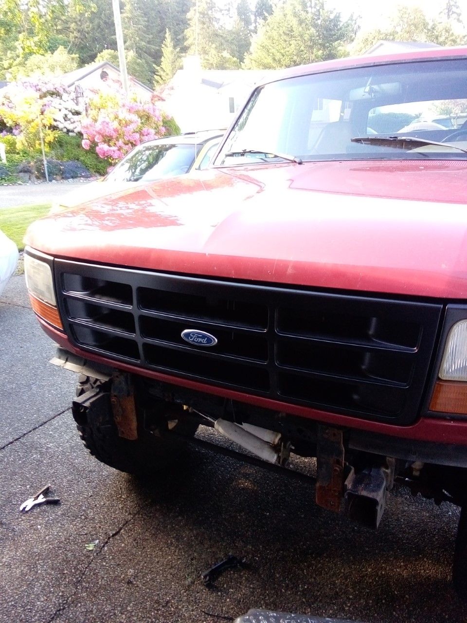 Red 1994 Ford Bronco front view with black grille and visible suspension