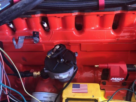 1992 Jeep Wrangler - A close-up view of a red engine block with spark plugs, a distributor cap, and an MSD ignition coil. Wires and a filter are also visible.