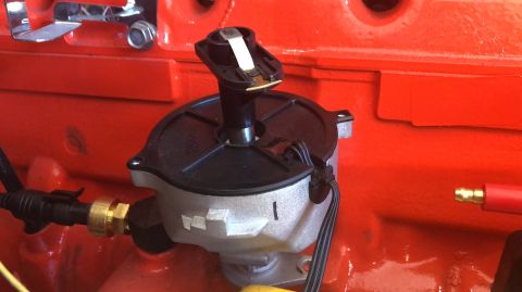 1992 Jeep Wrangler - A close-up view of a distributor cap and rotor assembly mounted on an orange engine block.