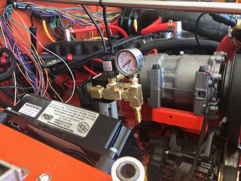 1992 Jeep Wrangler - Close-up view of the engine bay of a 1992 Jeep Wrangler, showing the air conditioning compressor, wiring harness, and an MSD ignition box.