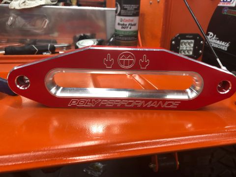 1992 Jeep Wrangler - A red aluminum winch fairlead with "POLYPERFORMANCE" engraved on it is mounted on an orange surface, possibly a vehicle part. The fairlead…
