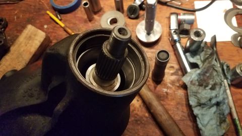 1985 Ford Bronco - A close-up view of a splined shaft protruding from a dark-colored automotive component, likely a steering gear box, resting on a wooden wor…