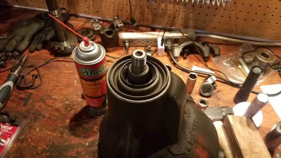 Differential housing with splined shaft and tools on a workbench.