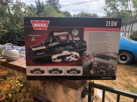 1992 Jeep Wrangler - A box for a WARN Zeon SpyDura synthetic rope winch is displayed outdoors. The box features an image of the winch and a Jeep Wrangler.