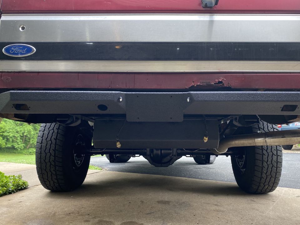 1994 Ford Bronco rear bumper, axle, and tires. Ford logo visible on tailgate