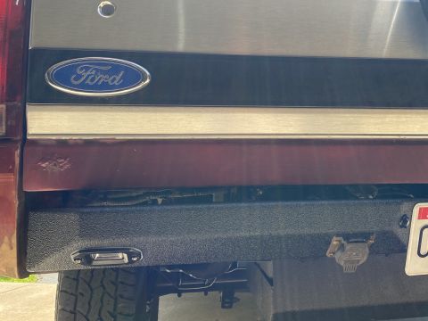 1994 Ford Bronco - Rear view of a 1994 Ford Bronco showing the Ford emblem and a textured aftermarket bumper.