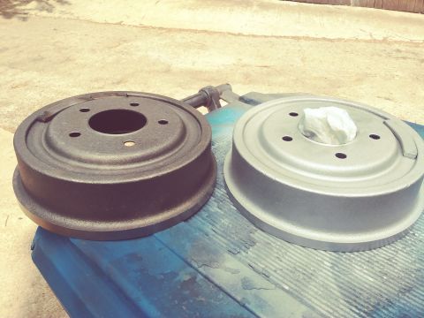 1996 Ford Bronco - A comparison of a used brake drum next to a newly painted one, possibly for a vehicle restoration project.