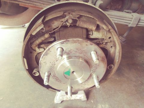 1996 Ford Bronco - Close-up view of a rear drum brake assembly, showing the brake shoes and drum.
