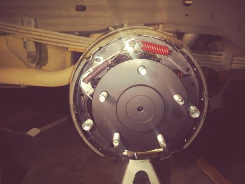 1996 Ford Bronco - Close-up of a vehicle's rear drum brake assembly, showing new components and springs.
