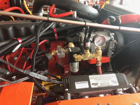 1992 Jeep Wrangler - Close-up view of engine components, including a pressure gauge and warning label, within a vehicle's engine bay.