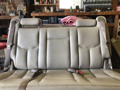 1980 Ford Bronco - Car seat with seatbelts in a workshop setting.