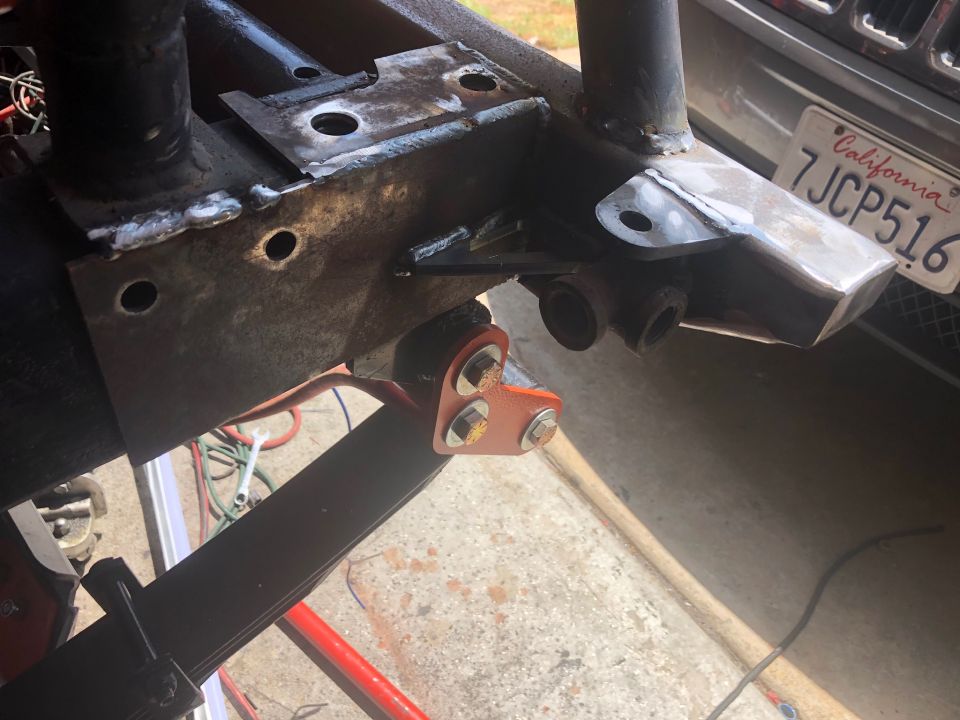 Close-up of Jeep frame showing suspension bracket modification and part of a California license plate