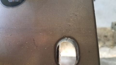 1985 Ford Bronco - Metal bracket with a slotted hole and weld detail, likely a vehicle component.