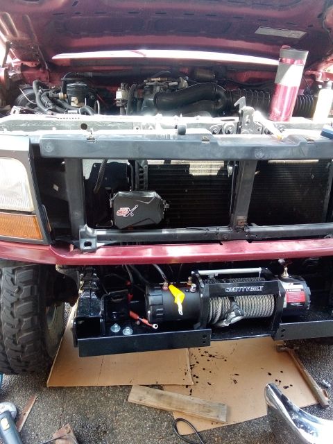 1994 Ford Bronco - Front view of a 1994 Ford Bronco with its hood open, revealing the engine and a newly installed winch.