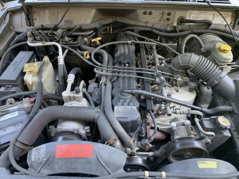 2000 Jeep Cherokee - Engine bay of a 2000 Jeep Cherokee, showing various mechanical parts and wiring.