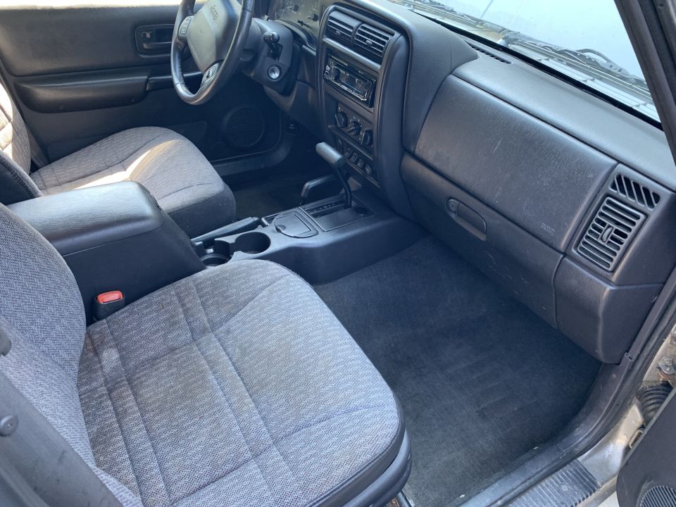 Interior of a 2000 Jeep Cherokee showing front seats and dashboard