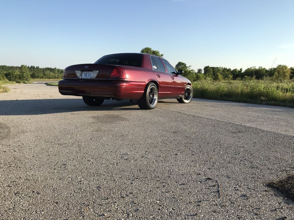 Red 2004 Ford Crown Victoria, rear view, aftermarket wheels, on asphalt road