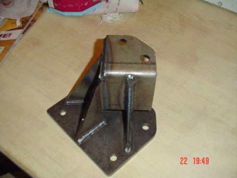1989 Ford Bronco - A custom metal bracket, likely for automotive modification, is shown on a table.