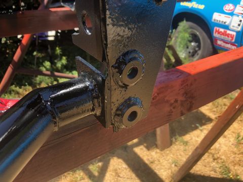 1992 Jeep Wrangler - A close-up of a black painted metal part, with a blue race car in the background.