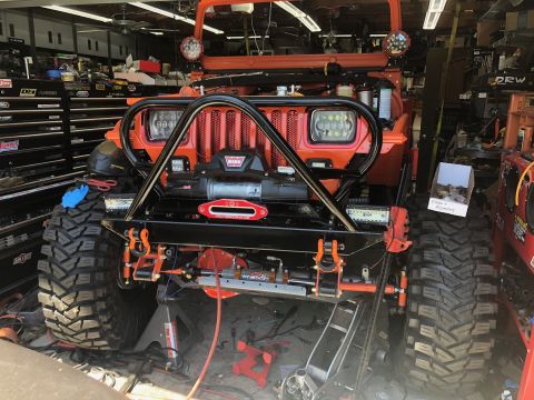 1992 Jeep Wrangler - Modified orange Jeep Wrangler in a garage, a winch and custom front-end armor.